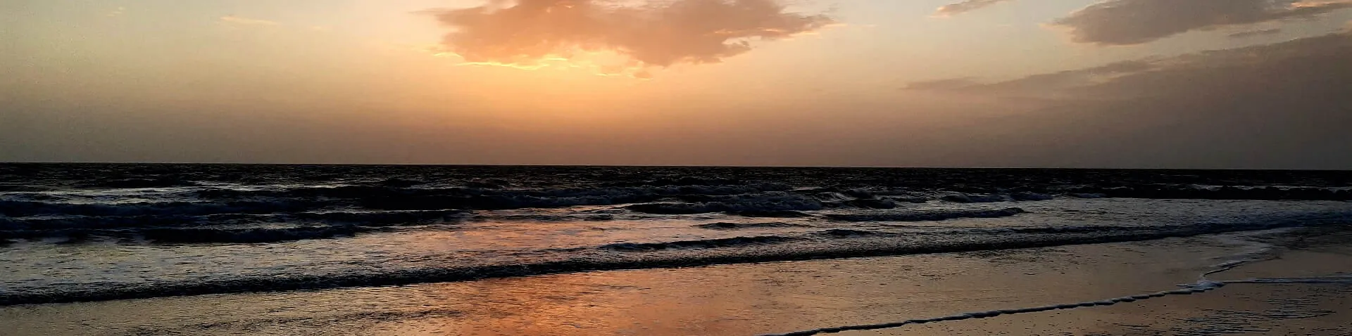 Rötlicher Himmel nach Sonnenuntergang am Meer