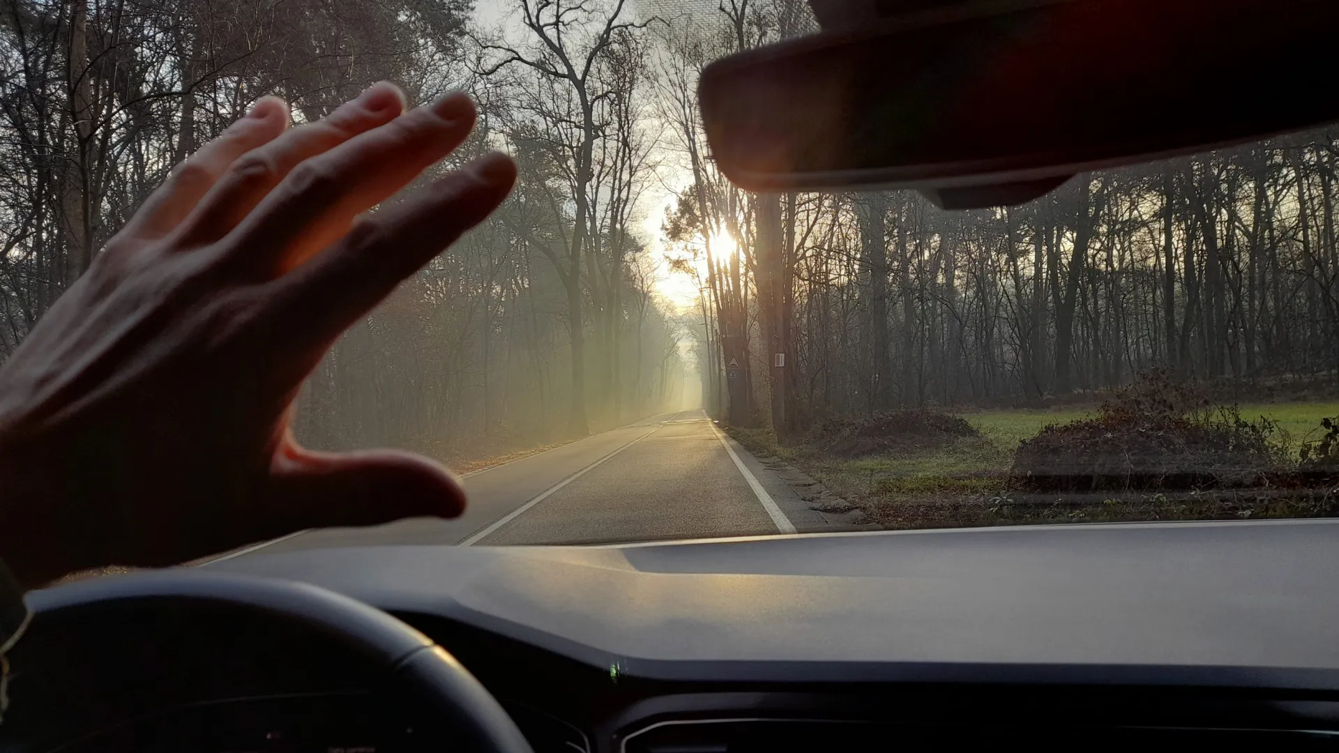 Person beim Autofahren wird von der Sonne geblendet